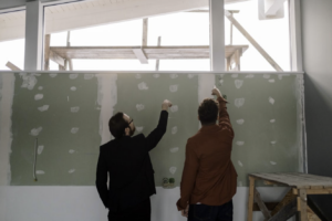 Contractors inspecting drywall installation and wall preparation during a home renovation project