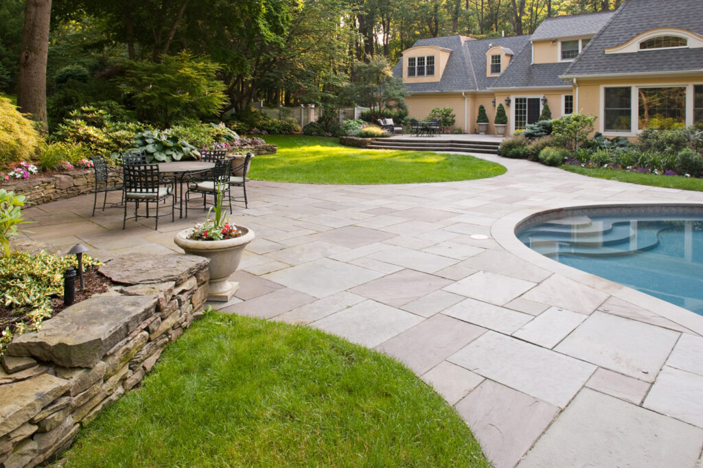North Shore MA bluestone patio with pool, outdoor seating, and custom landscape design
