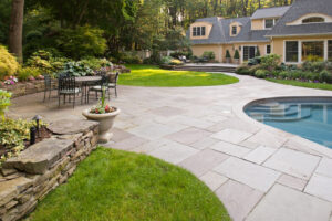 North Shore MA bluestone patio with pool, outdoor seating, and custom landscape design
